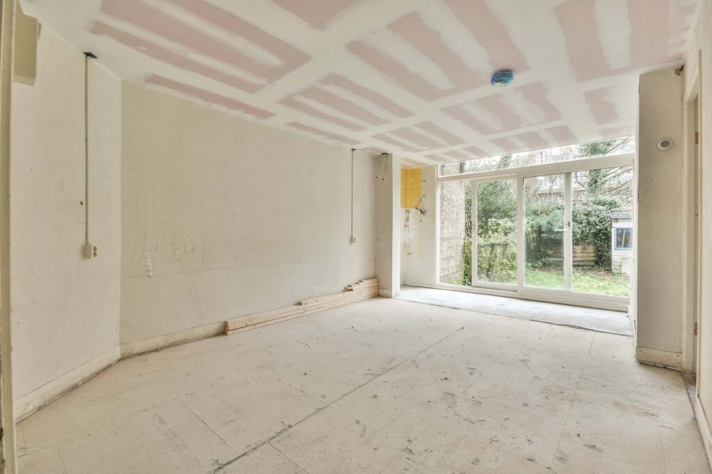 Unfinished drywall living space with sliding doors before painting