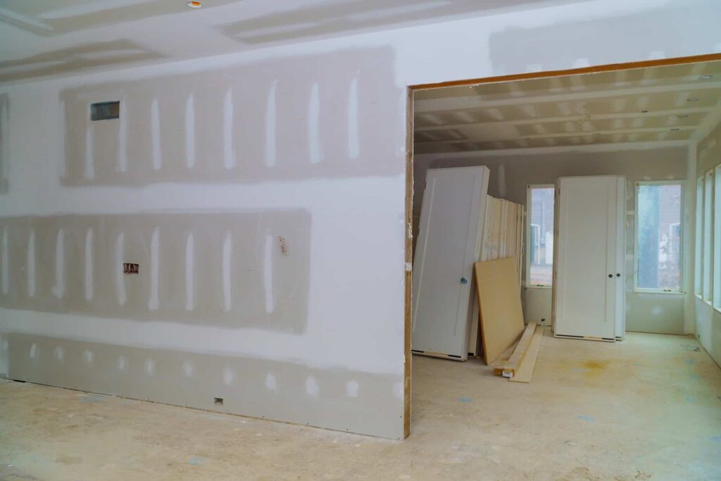 Unfinished drywall room with stacked doors before painting in Chico, CA