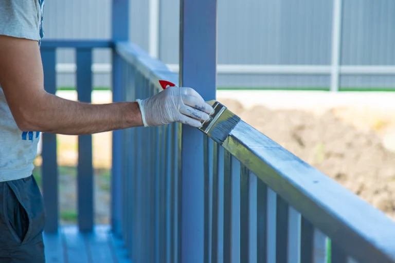 Professional painter applying paint to outdoor railing in Chico, CA