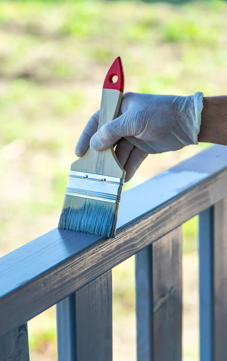 Gloved painter hand brushing railing with precision in Chico, CA