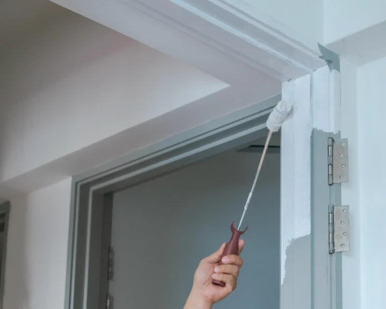 Painter using small roller on door frame in Chico, CA home